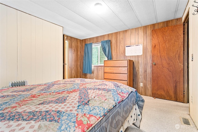 bedroom featuring carpet and wood walls