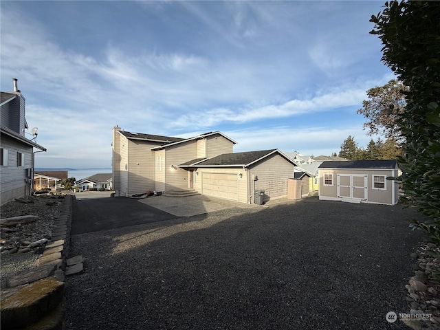 view of side of property featuring a garage and a shed