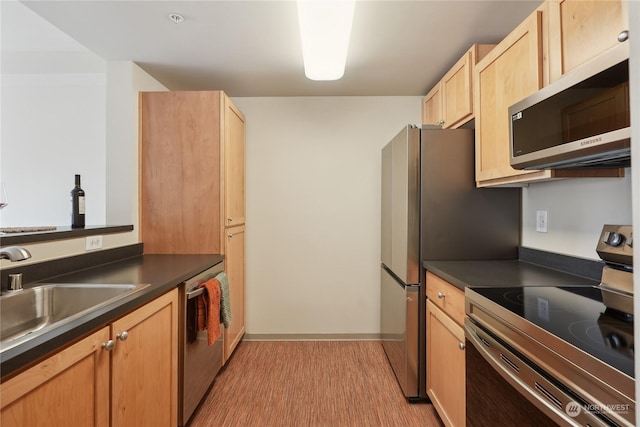 kitchen with sink, light hardwood / wood-style flooring, light brown cabinets, and appliances with stainless steel finishes