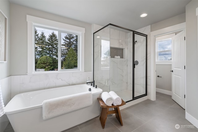 bathroom featuring tile walls, tile patterned floors, plus walk in shower, and a healthy amount of sunlight