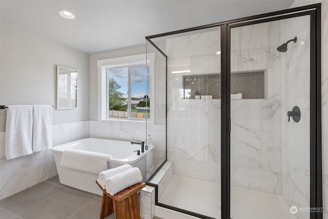 bathroom featuring independent shower and bath, tile patterned flooring, and tile walls