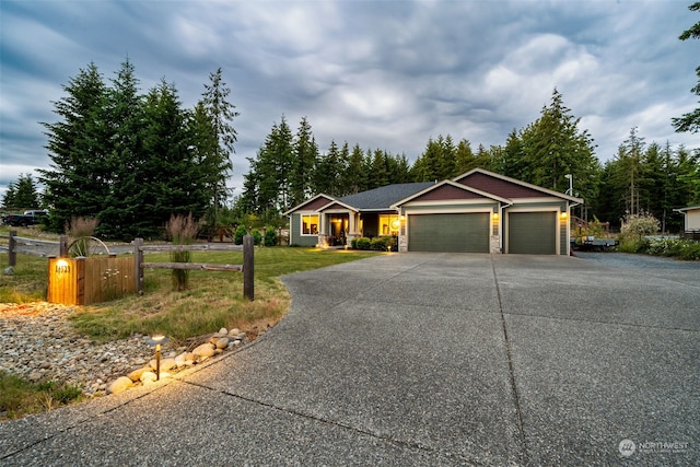 ranch-style home featuring a garage and a front lawn