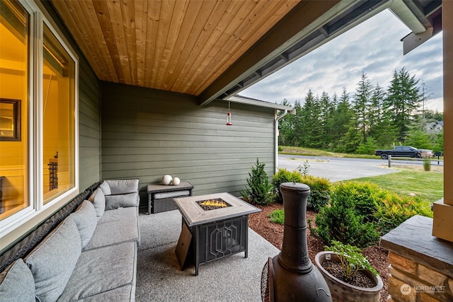 view of patio with an outdoor living space with a fire pit