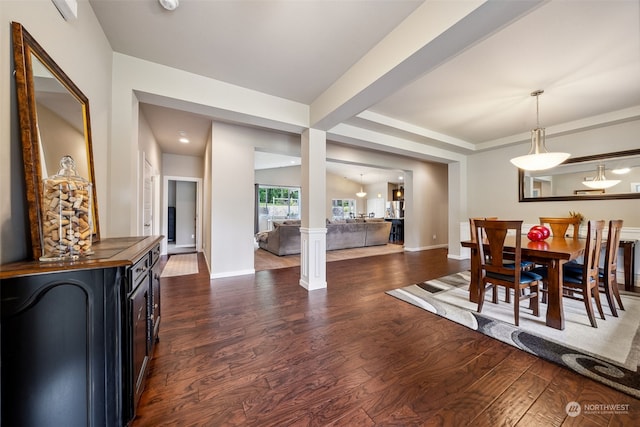 dining room with lofted ceiling, dark hardwood / wood-style flooring, and ornate columns