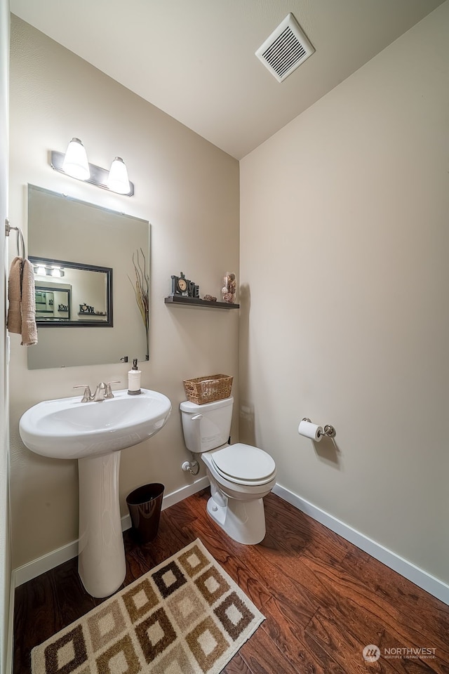 bathroom with hardwood / wood-style floors and toilet