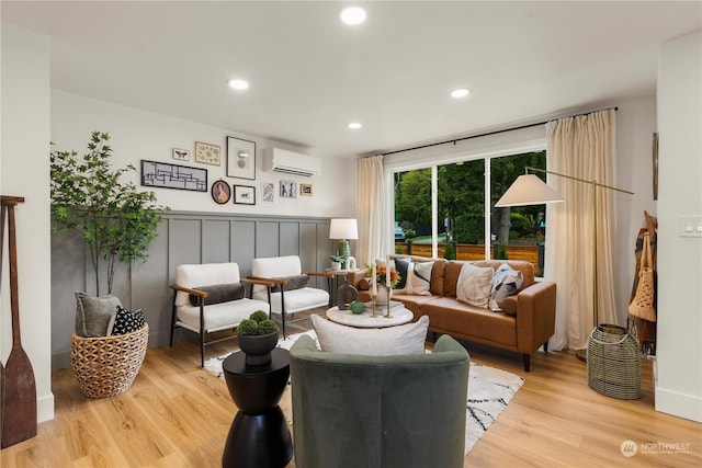 living room with light hardwood / wood-style flooring and an AC wall unit