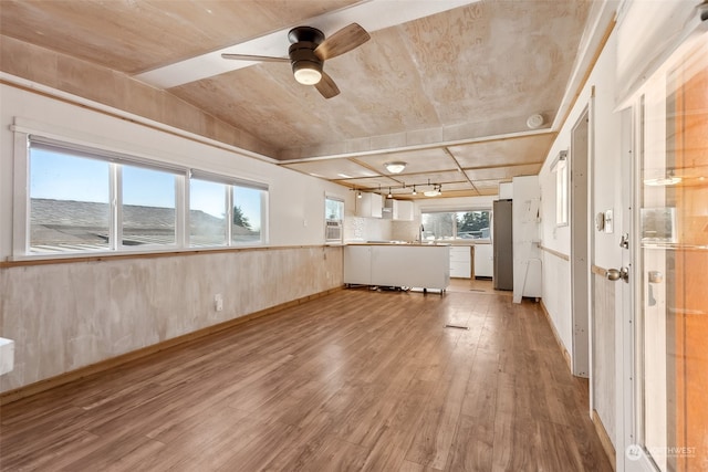 unfurnished living room with ceiling fan and light hardwood / wood-style flooring