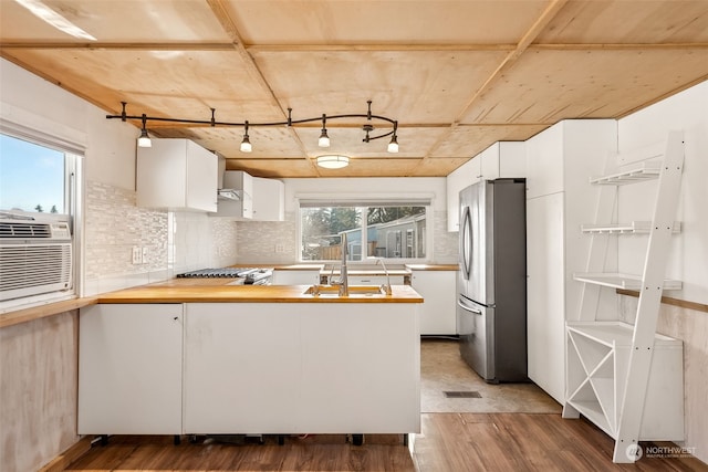 kitchen with stainless steel refrigerator, white cabinetry, dark hardwood / wood-style floors, and wood counters