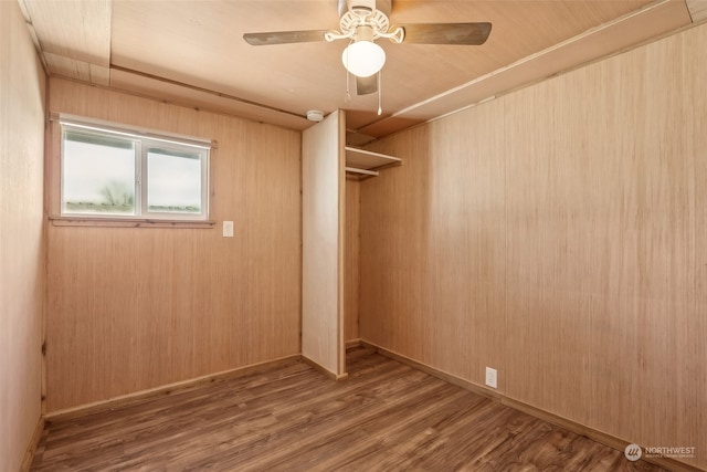 spare room featuring ceiling fan, hardwood / wood-style floors, and wooden walls