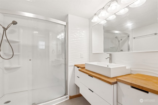 bathroom featuring vanity and a shower with door