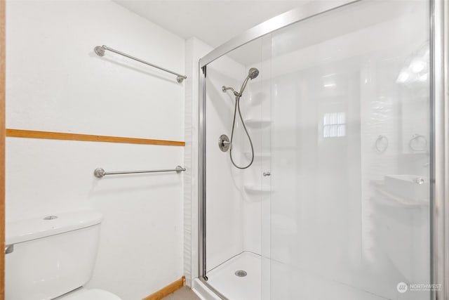 bathroom with toilet and a shower with shower door