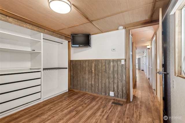 interior space featuring wood ceiling, wood-type flooring, and wooden walls