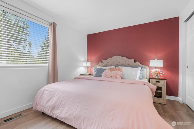 bedroom featuring hardwood / wood-style floors and a closet