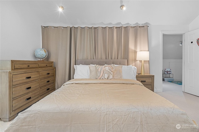 bedroom featuring vaulted ceiling and light carpet