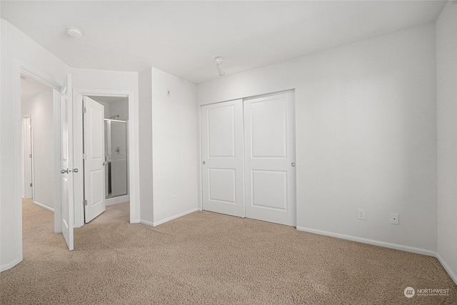 unfurnished bedroom featuring light colored carpet and a closet