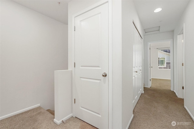 hallway featuring light colored carpet