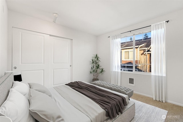 bedroom featuring light colored carpet and a closet