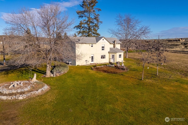 rear view of property featuring a lawn