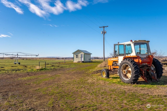 view of yard featuring a rural view and a storage unit