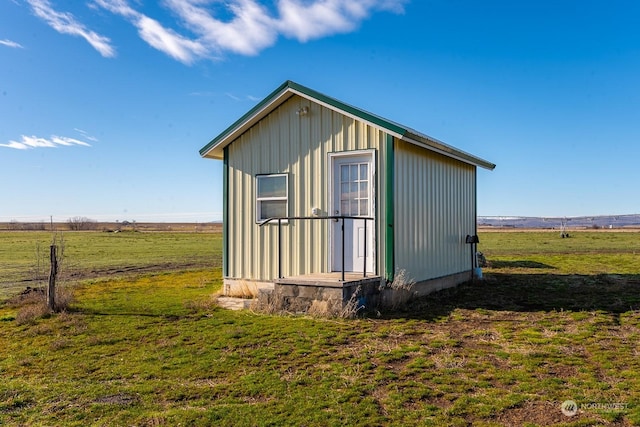 view of outdoor structure with a yard and a rural view