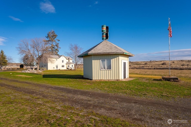 view of side of home featuring an outbuilding and a lawn