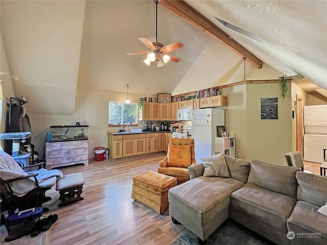 living room with stacked washer and dryer, ceiling fan, beam ceiling, high vaulted ceiling, and light wood-type flooring