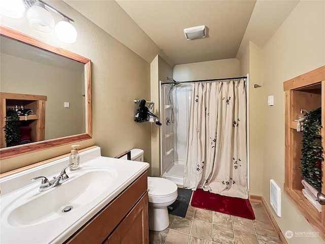 bathroom with vanity, curtained shower, and toilet