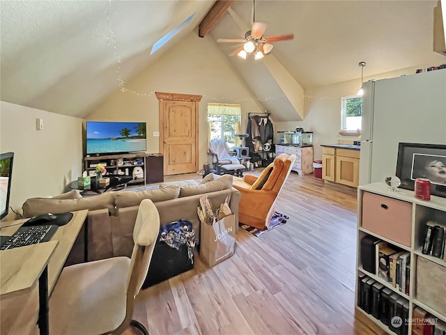 living room with ceiling fan, high vaulted ceiling, beamed ceiling, and light wood-type flooring