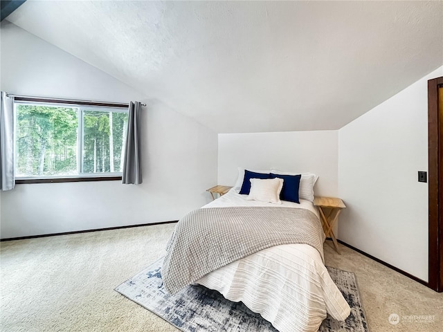 carpeted bedroom with lofted ceiling and a textured ceiling