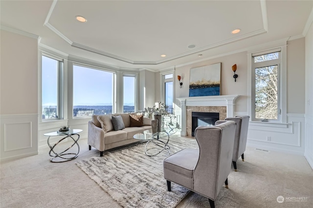 carpeted living room featuring a tray ceiling, crown molding, and a healthy amount of sunlight