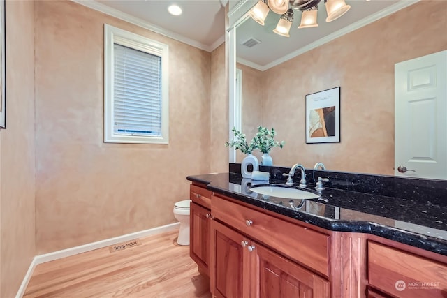 bathroom featuring vanity, crown molding, wood-type flooring, and toilet