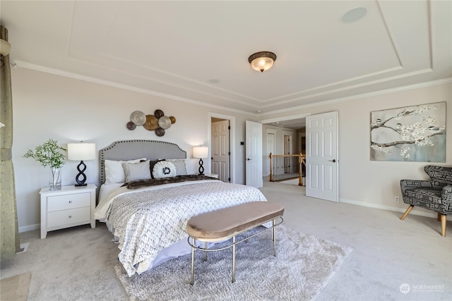 carpeted bedroom featuring a raised ceiling and ornamental molding