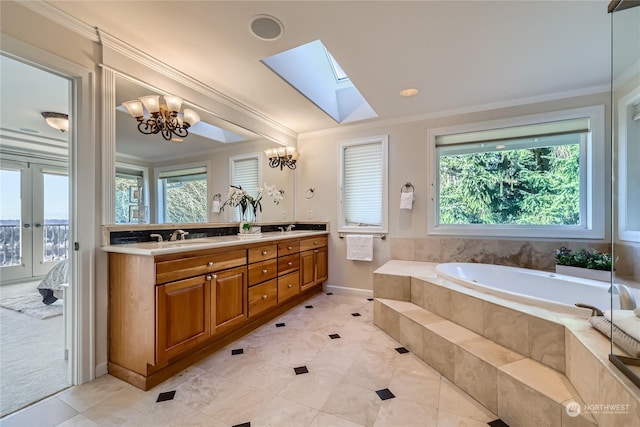 bathroom with crown molding, a skylight, vanity, tiled bath, and tile patterned floors