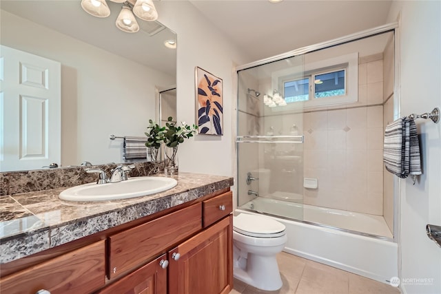 full bathroom with tile patterned flooring, vanity, enclosed tub / shower combo, and toilet