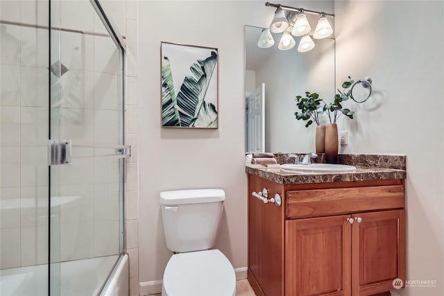 full bathroom featuring vanity, bath / shower combo with glass door, and toilet