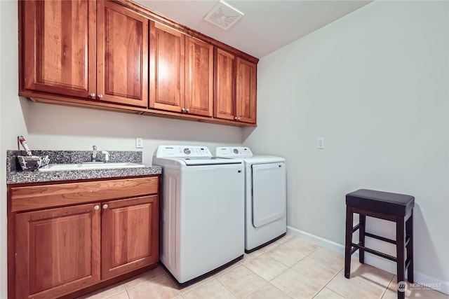 clothes washing area with light tile patterned flooring, cabinets, separate washer and dryer, and sink