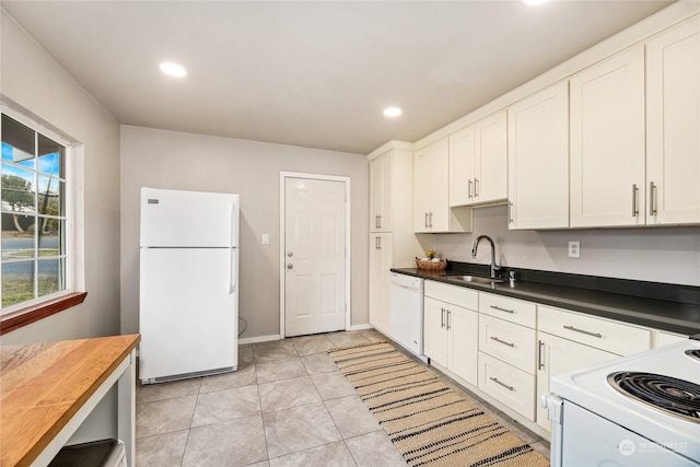 kitchen with sink, white appliances, light tile patterned floors, butcher block countertops, and white cabinetry