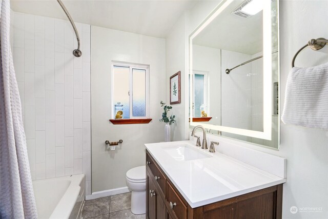 full bathroom featuring vanity, tile patterned flooring, tiled shower / bath combo, and toilet