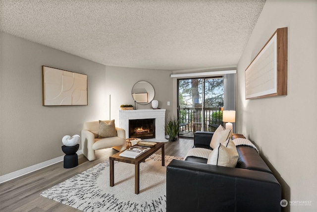 living room featuring hardwood / wood-style floors, a fireplace, and a textured ceiling