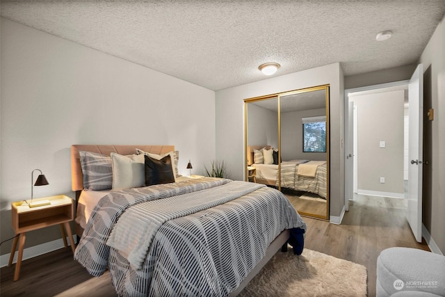 bedroom with wood-type flooring, a closet, and a textured ceiling