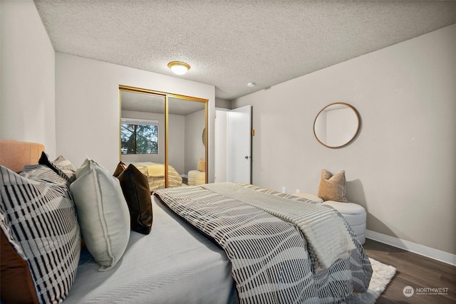 bedroom featuring dark wood-type flooring, a closet, and a textured ceiling