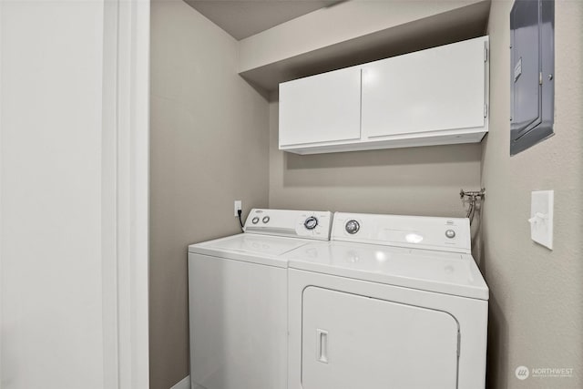 laundry room featuring cabinets, electric panel, and washer and clothes dryer