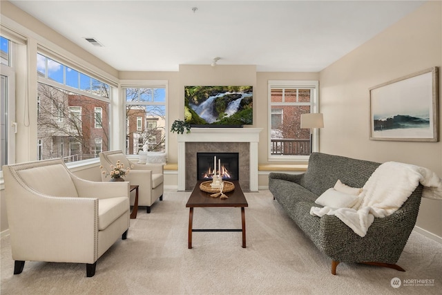 interior space with light colored carpet and a tiled fireplace