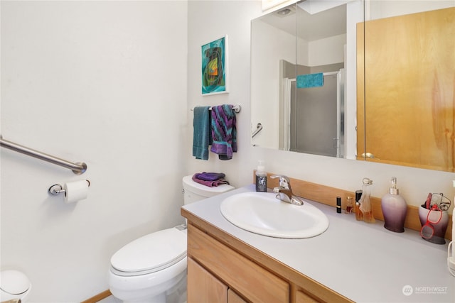 bathroom featuring vanity, toilet, and an enclosed shower