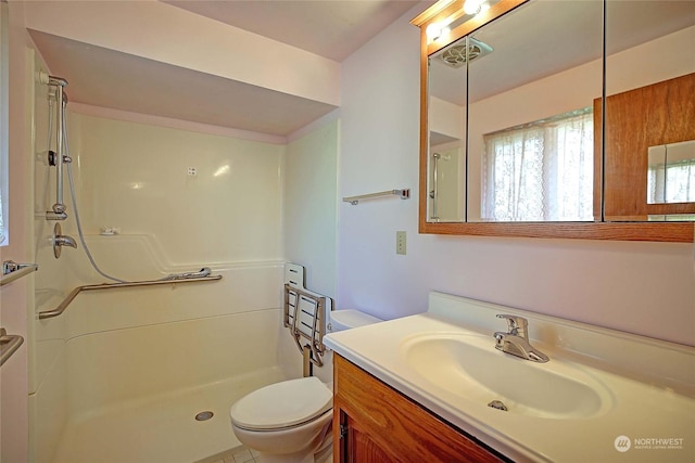 bathroom featuring vanity, toilet, and a shower