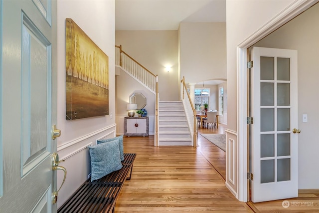 foyer entrance with a towering ceiling and light hardwood / wood-style floors