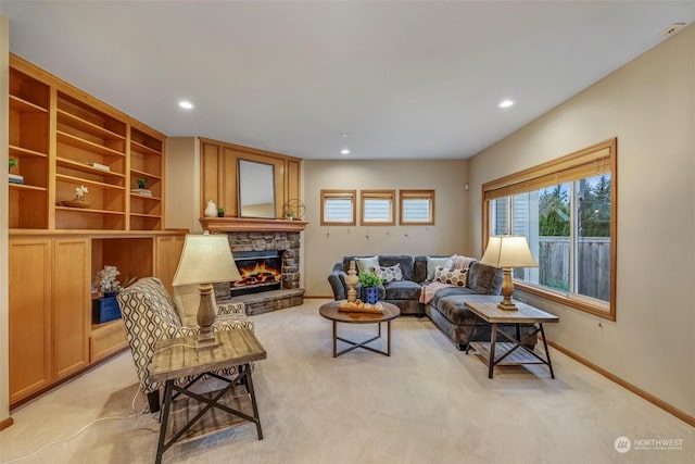 carpeted living room featuring a stone fireplace