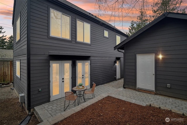 back house at dusk featuring a patio