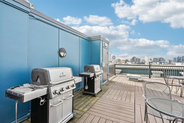 wooden terrace with a water view and a grill