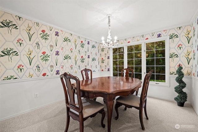 carpeted dining area with a chandelier, ornamental molding, baseboards, and wallpapered walls